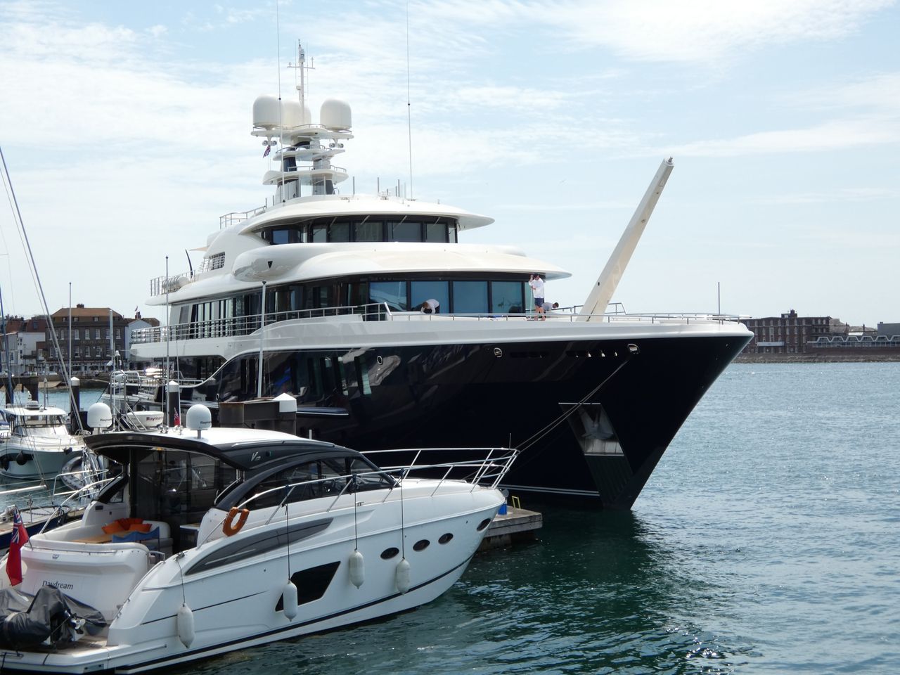 A luxurious yacht docked at Portsmouth Marina under a clear blue sky.